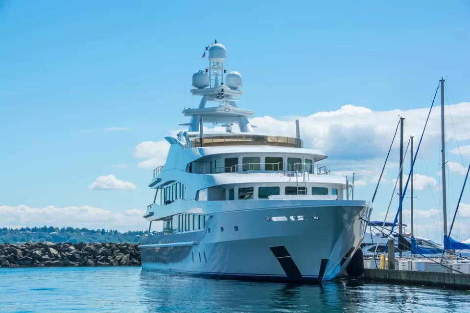 A very large yacht at berth in Washington, with wooded hills in the background.